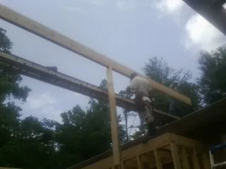 Carpenter setting a ridge beam over a new addition frame — Ice Dam Removal by Roofing Brothers in Commercial Point
