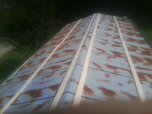 Rusted metal roof panels with new wood purlins before replacement — Storm Damage Roof Repair in Commercial Point by Roofing Brothers
