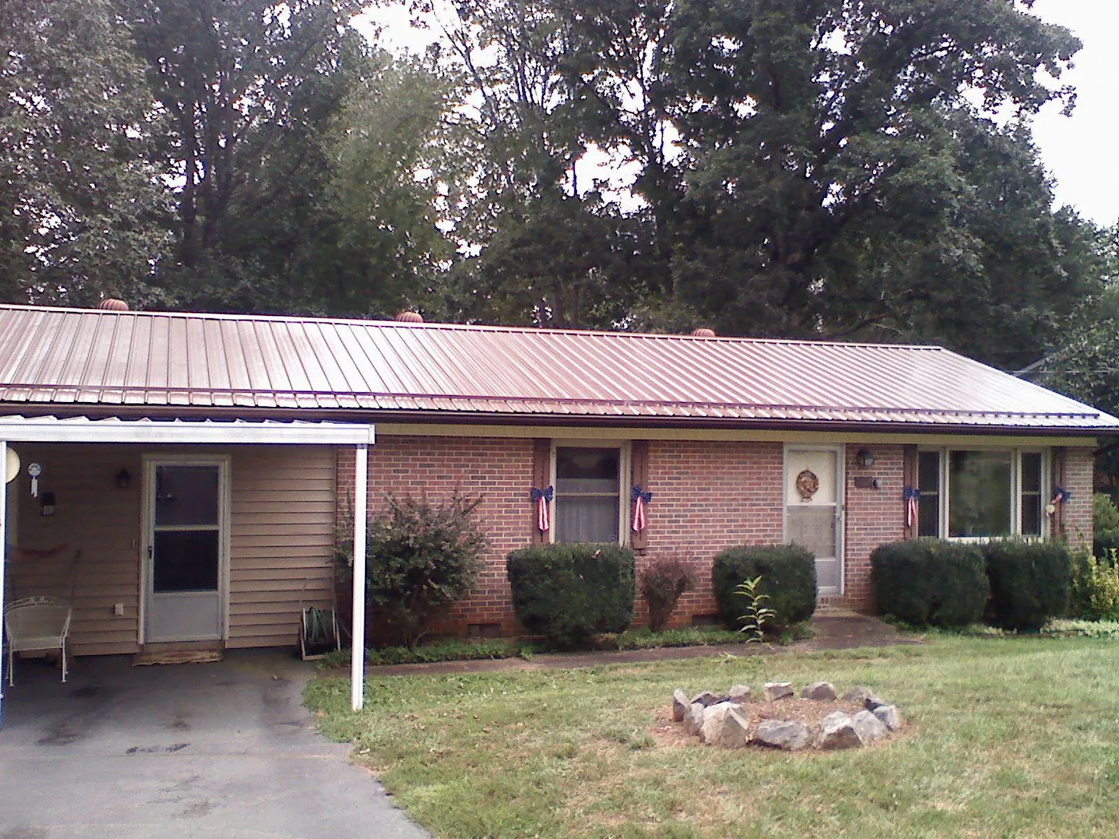 Bronze metal roof and carport on a brick ranch home — Roof Repair work by our crew in Commercial Point